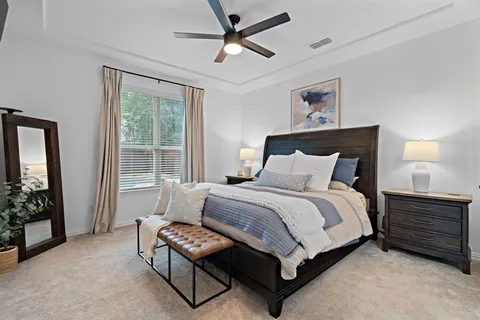 a bedroom with a bed dresser and a window