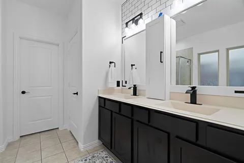 a bathroom with a double vanity sink and mirror