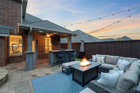 a backyard of a house with a couch and chairs