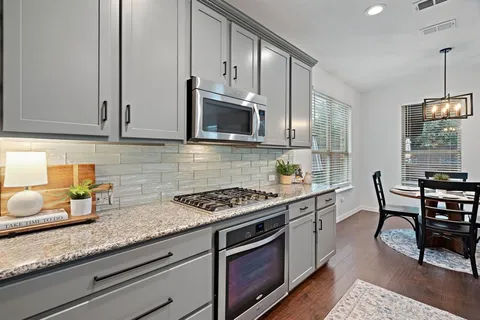 a kitchen with stainless steel appliances granite countertop a stove a sink and a microwave