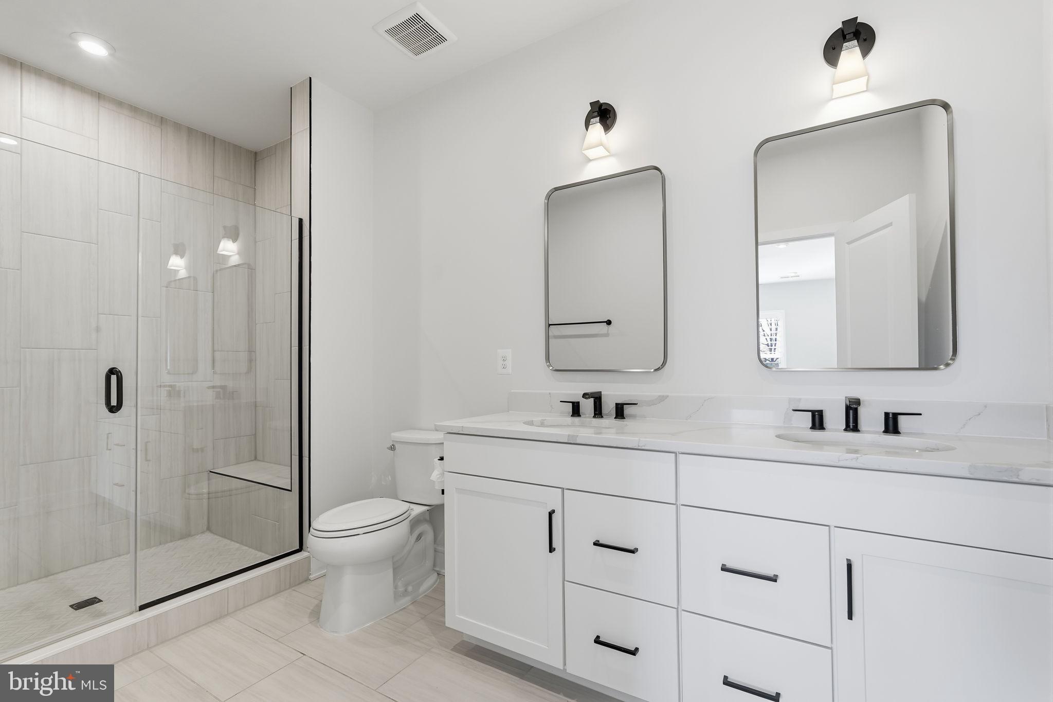 14679 Grand Cru Loop Gainesville, VA 20155 - Photo 34 of 41 a bathroom with double vanity sinks a toilet a mirror and shower