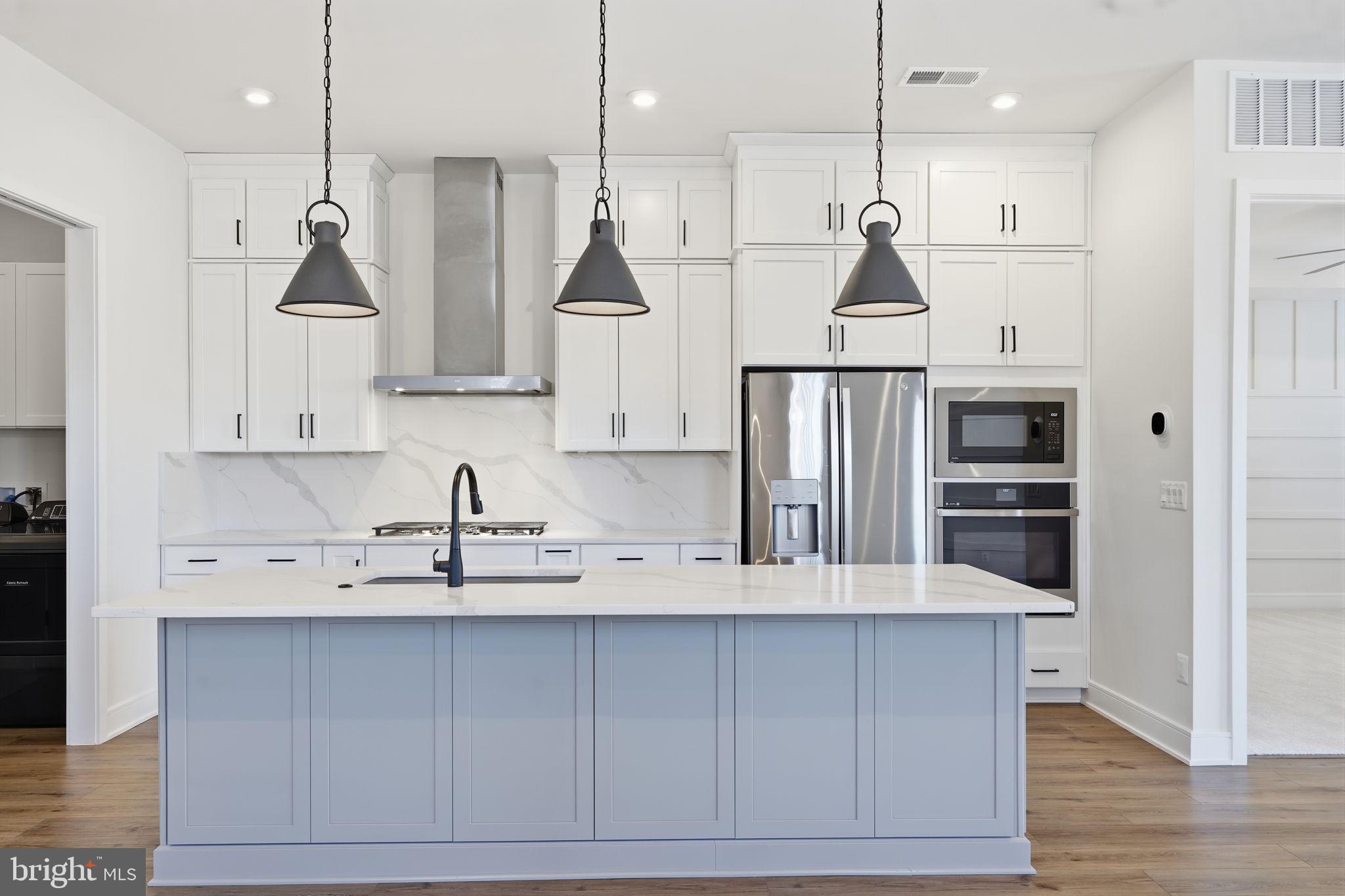 14679 Grand Cru Loop Gainesville, VA 20155 - Photo 6 of 41 a kitchen with kitchen island white cabinets and stainless steel appliances