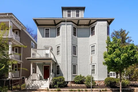 a front view of a house with plants