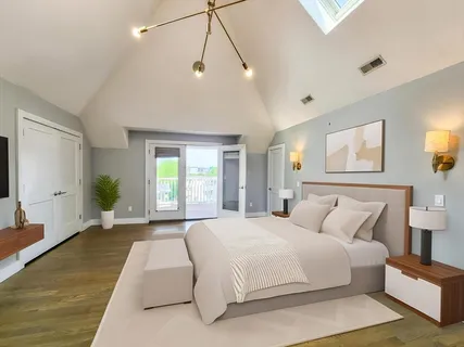 a spacious bedroom with a large bed and a chandelier