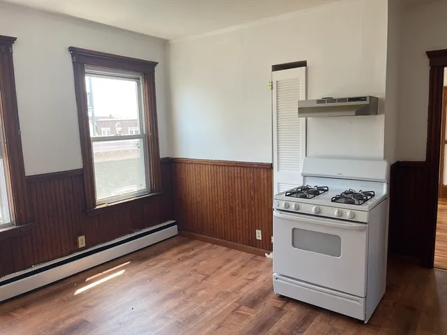 a kitchen with a stove and a wooden cabinet