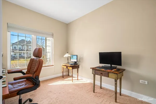 a view of a workspace with furniture and a window