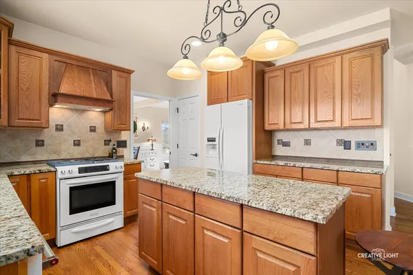 a kitchen with stainless steel appliances granite countertop a stove a sink and a microwave