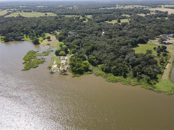 an aerial view of a houses with a yard and lake view