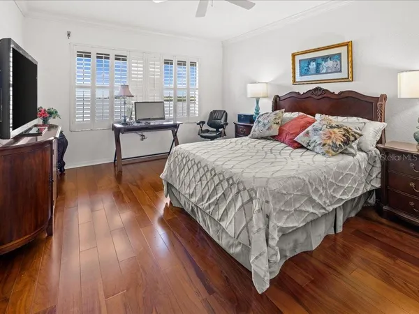 a spacious bedroom with a bed and a flat screen tv
