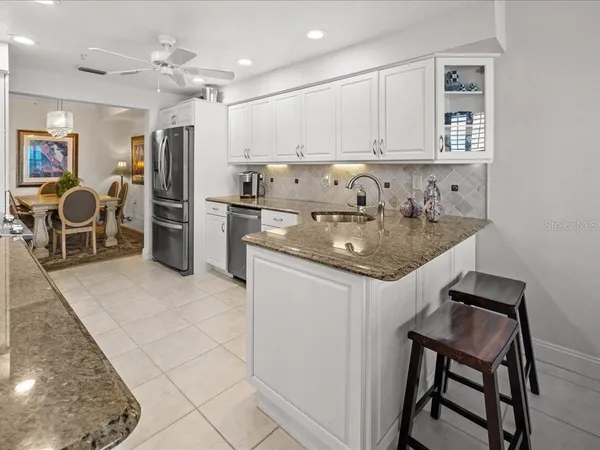 a kitchen that has a lot of cabinets and refrigerator in it