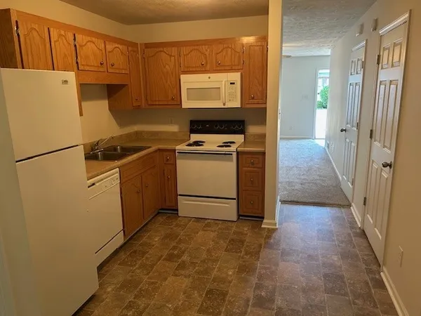 a kitchen with a stove a refrigerator and a more cabinets