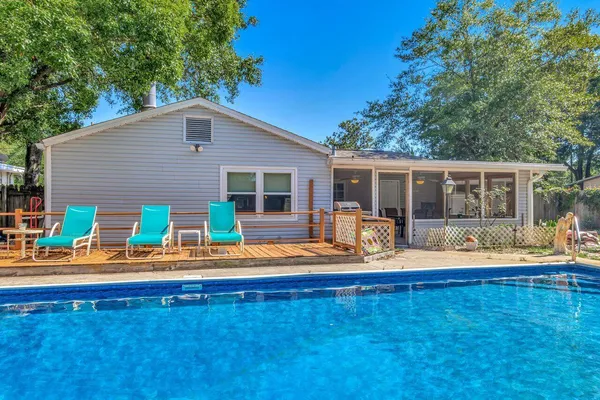 a house view with swimming pool and wooden bench