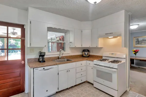 a kitchen with white cabinets and appliances