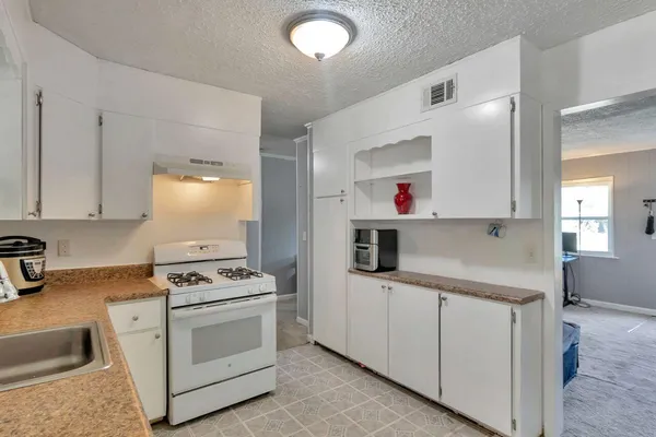 a kitchen with white cabinets and white appliances