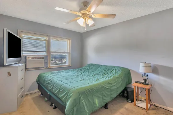 a bedroom with a bed and a flat tv screen on dresser