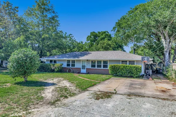 a front view of a house with a yard and trees