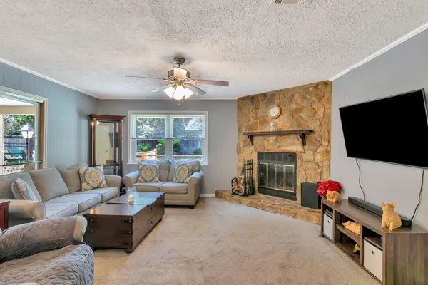 a living room with furniture a flat screen tv and a fireplace