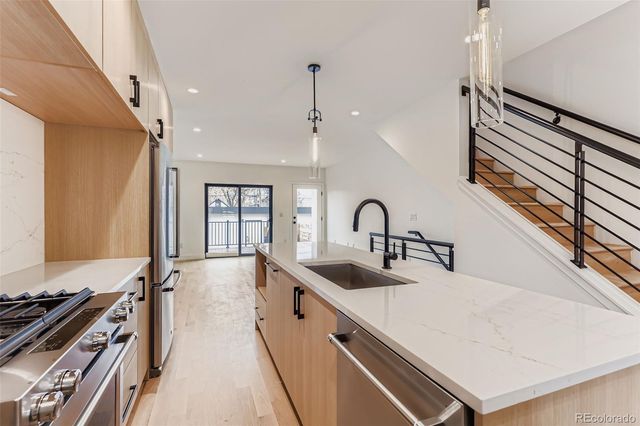 a large white kitchen with sink stove and cabinets