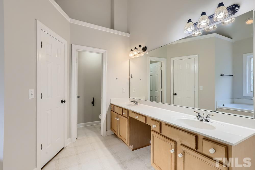 6040 Big Sandy Drive Raleigh, NC 27616 - Photo 16 of 28 a bathroom with a double vanity sink a mirror and a shower