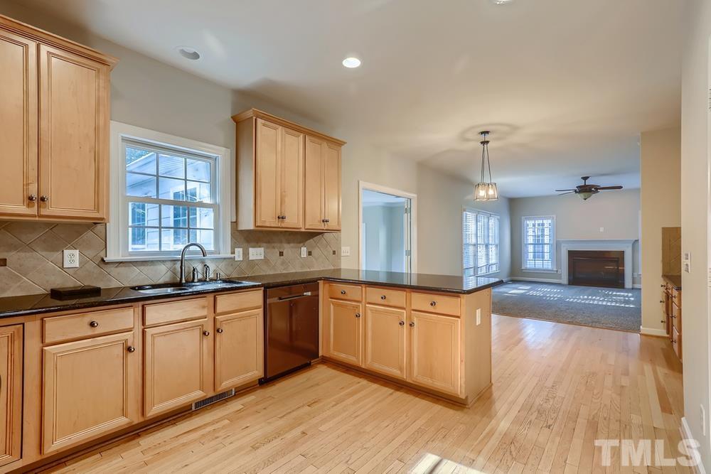 6040 Big Sandy Drive Raleigh, NC 27616 - Photo 7 of 28 a large kitchen with granite countertop a large center island a sink stainless steel appliances and cabinets