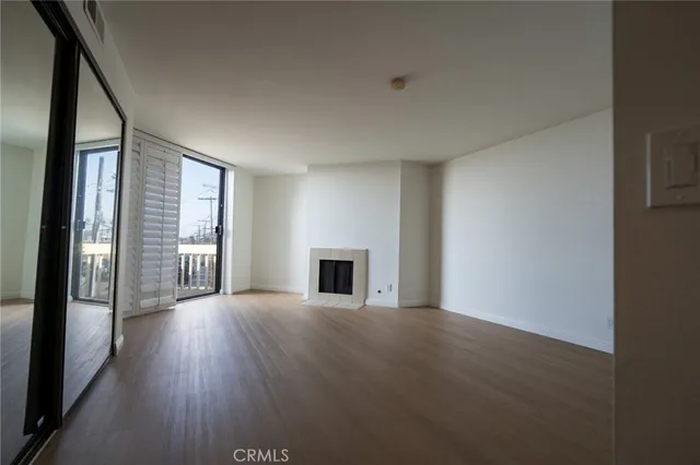 a view of a livingroom with wooden floor and a fireplace