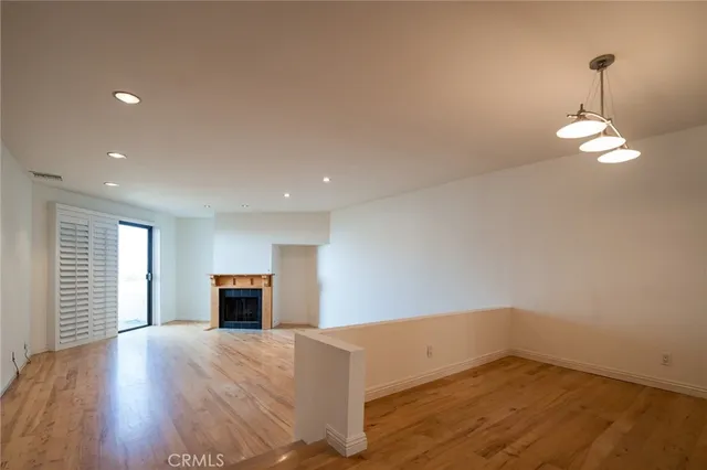 a view of empty room with wooden floor and fireplace