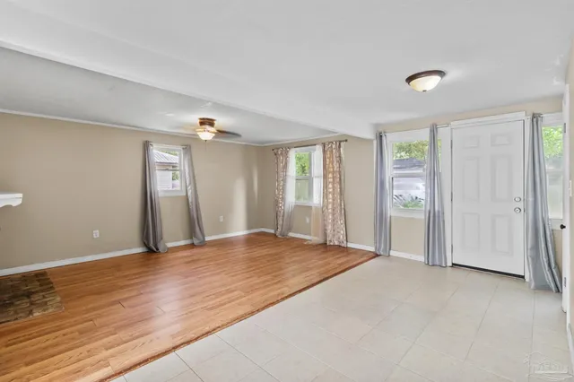 a view of an empty room with window and bathroom