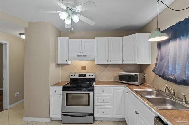 a kitchen with cabinets stainless steel appliances a sink and a stove