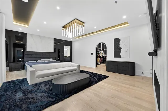 a spacious bedroom with a bed a flat screen tv and a large window