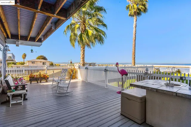 a view of a house with wooden deck and a palm tree