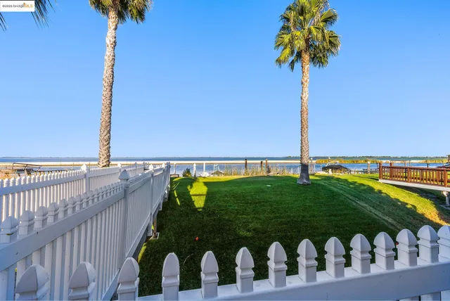 a vase of flowers sitting on a table near an ocean