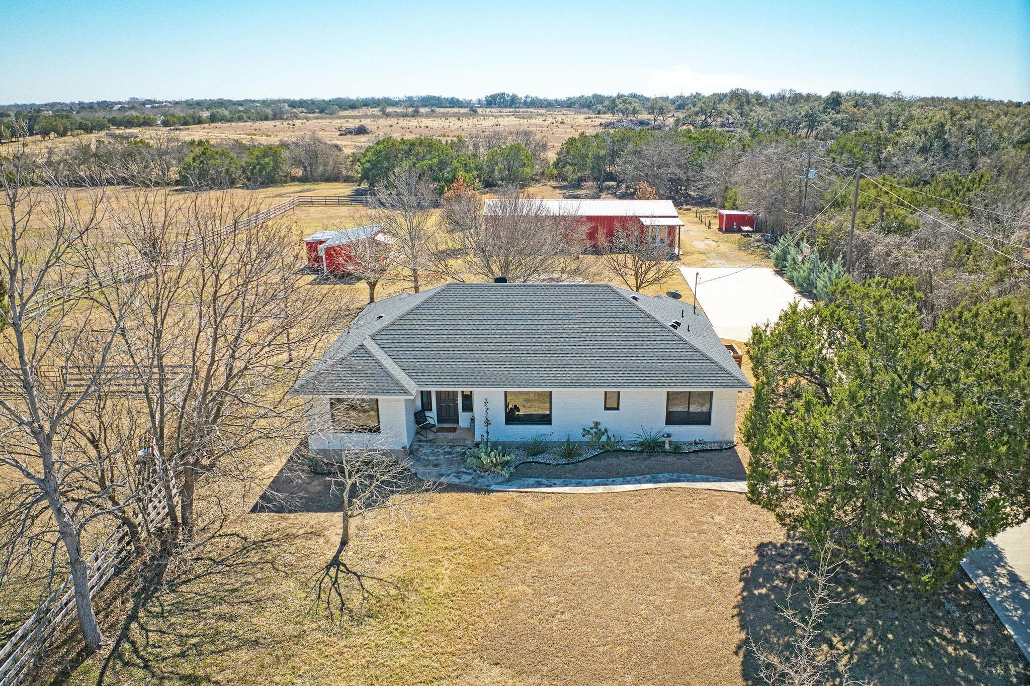 255 Glasscock Road Liberty Hill, TX 78642 - Photo 2 of 39 Aerial view of main house, studio apartment/barn and shop/hay barn