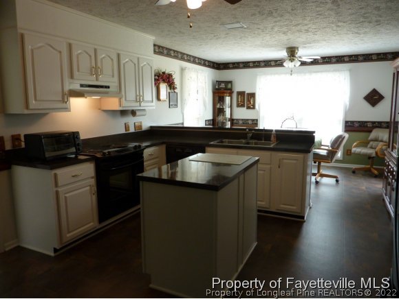 2588 Wade-Stedman Road Stedman, NC 28391 - Photo 10 of 25 a kitchen with stainless steel appliances granite countertop a sink a stove and a refrigerator