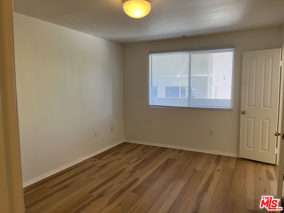 4501 Cedros Avenue, Unit 135 Sherman Oaks, CA 91403 - Photo 8 of 19 an empty room with wooden floor and windows