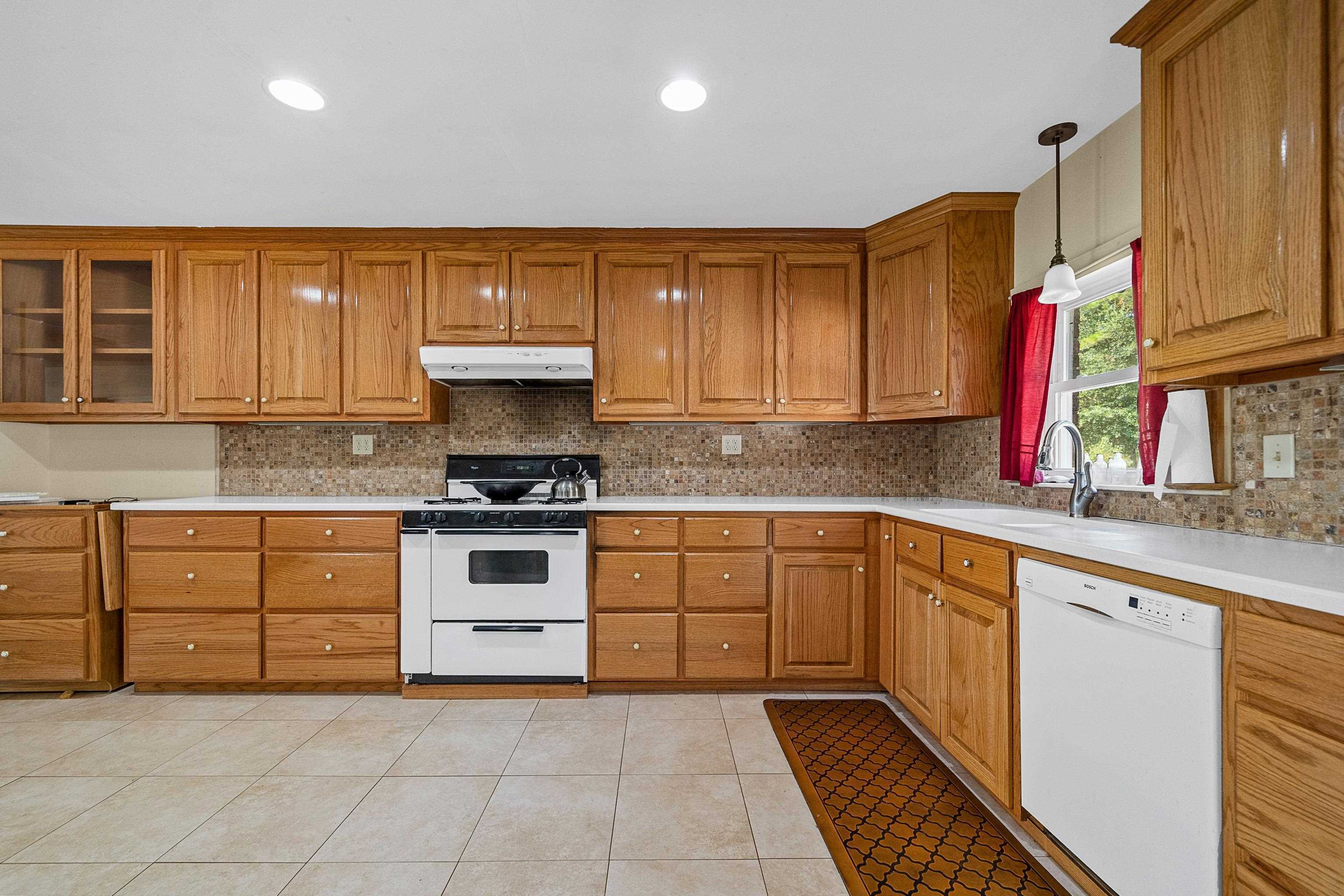 9350 Tompkins Road Stockton, AL 36579 - Photo 24 of 36 Kitchen with backsplash, brown cabinets, light tile patterned floors, and recessed lighting