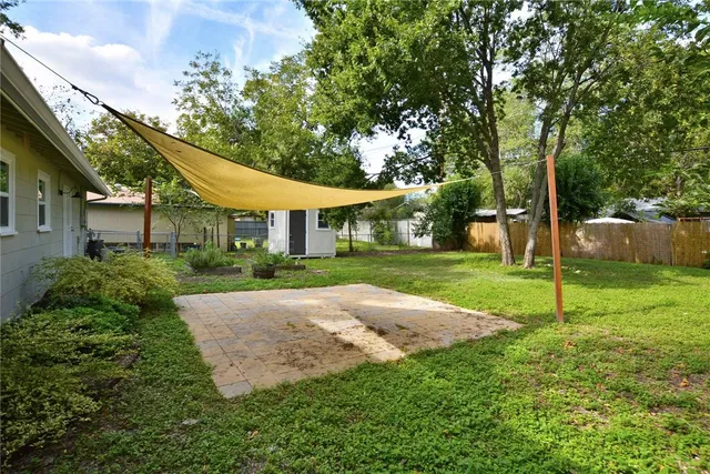a view of a house next to a yard with big trees
