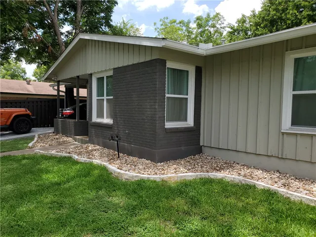 a view of backyard with barbeque grill and wooden fence