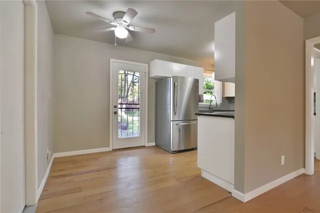 a view of a kitchen with refrigerator and a ceiling fan