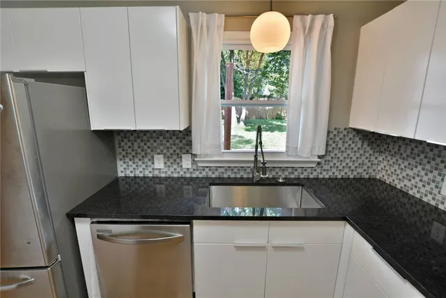 a kitchen with granite countertop a sink and a stove