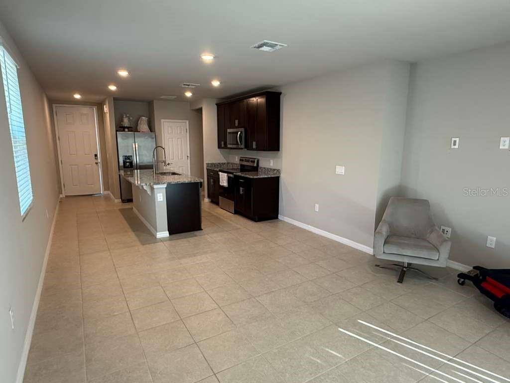 1788 Carnostie Road Winter Haven, FL 33884 - Photo 17 of 17 a living room with stainless steel appliances furniture a rug and kitchen view