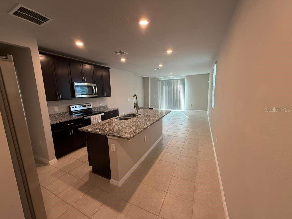 1788 Carnostie Road Winter Haven, FL 33884 - Photo 5 of 17 a large kitchen with stainless steel appliances a large counter top