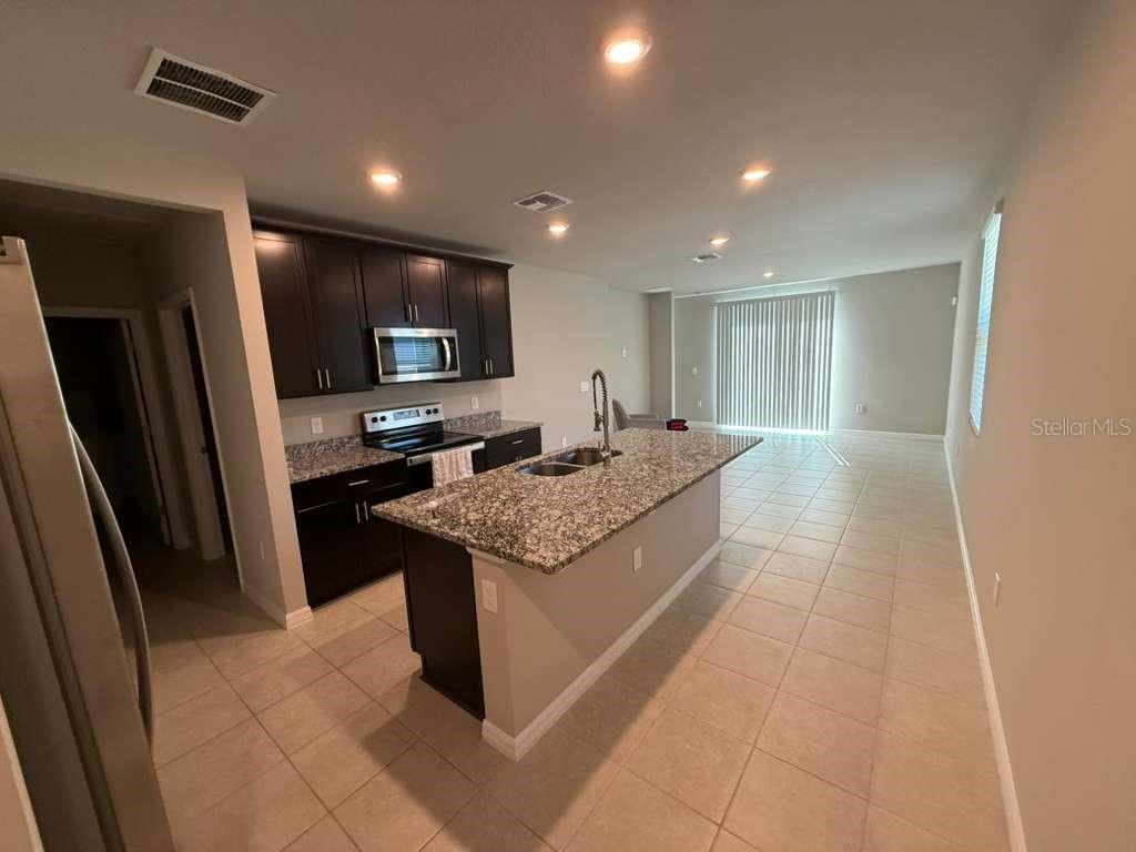 1788 Carnostie Road Winter Haven, FL 33884 - Photo 6 of 17 a kitchen with stainless steel appliances granite countertop a stove and a refrigerator