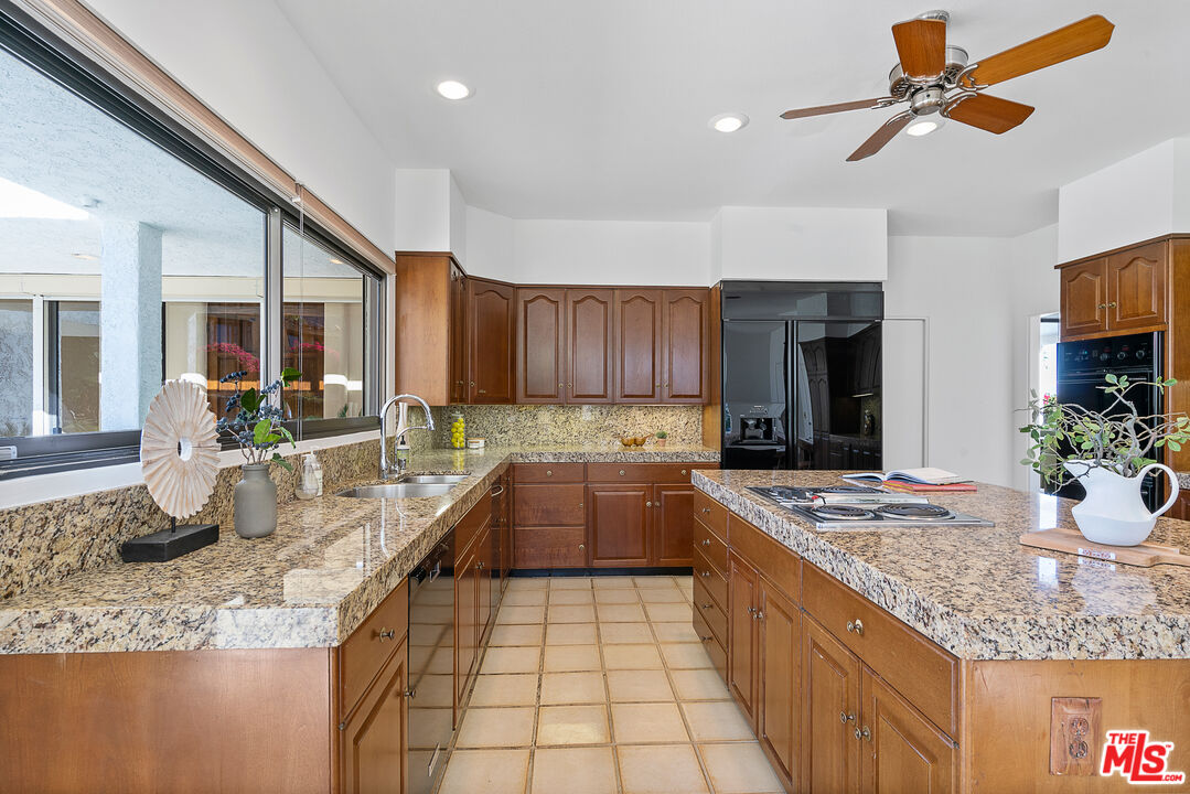 70551 Placerville Road Rancho Mirage, CA 92270 - Photo 27 of 42 a kitchen with stainless steel appliances granite countertop a sink stove and refrigerator