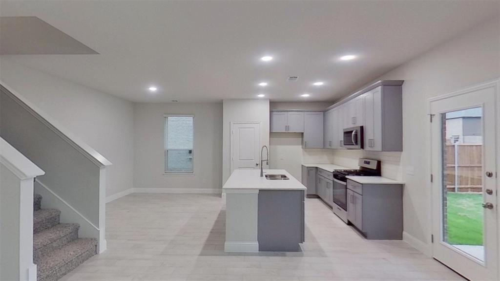 415 Magellan Road Seagoville, TX 75159 - Photo 2 of 12 a view of a kitchen with kitchen island white cabinets and stainless steel appliances