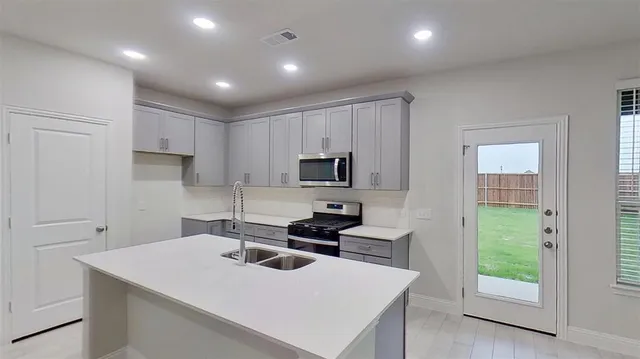 a kitchen with a sink a stove and cabinets