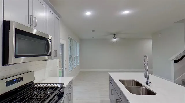 a kitchen with a sink a microwave and cabinets