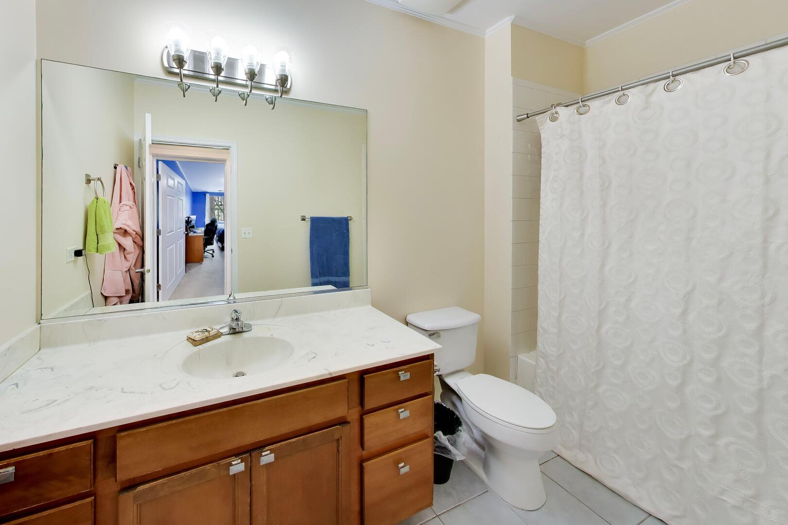 6436 Roosevelt Road, Unit 212 Oak Park, IL 60304 - Photo 14 of 22 a bathroom with a sink a toilet a mirror and shower curtain