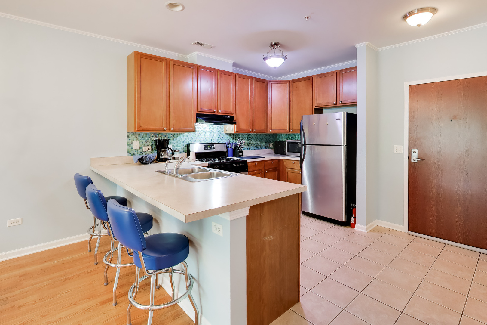 6436 Roosevelt Road, Unit 212 Oak Park, IL 60304 - Photo 6 of 22 a kitchen with stainless steel appliances a refrigerator a stove a sink cabinets and a dining table