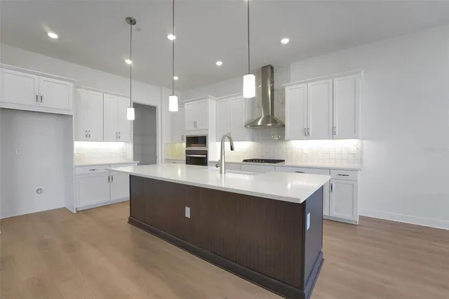 a kitchen with kitchen island a sink stainless steel appliances and white cabinets