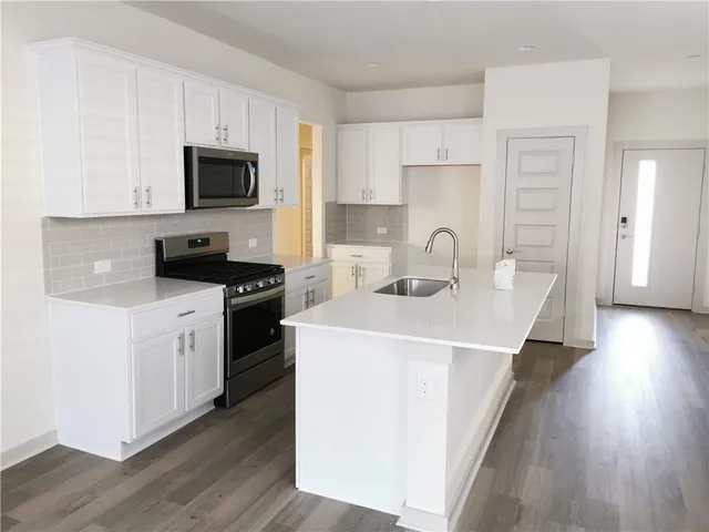 a kitchen with a sink a stove and microwave